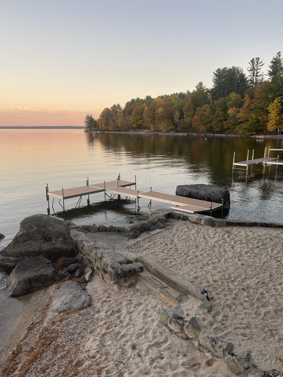 Private dock and sandy shoreline reaching into Sebago Lake