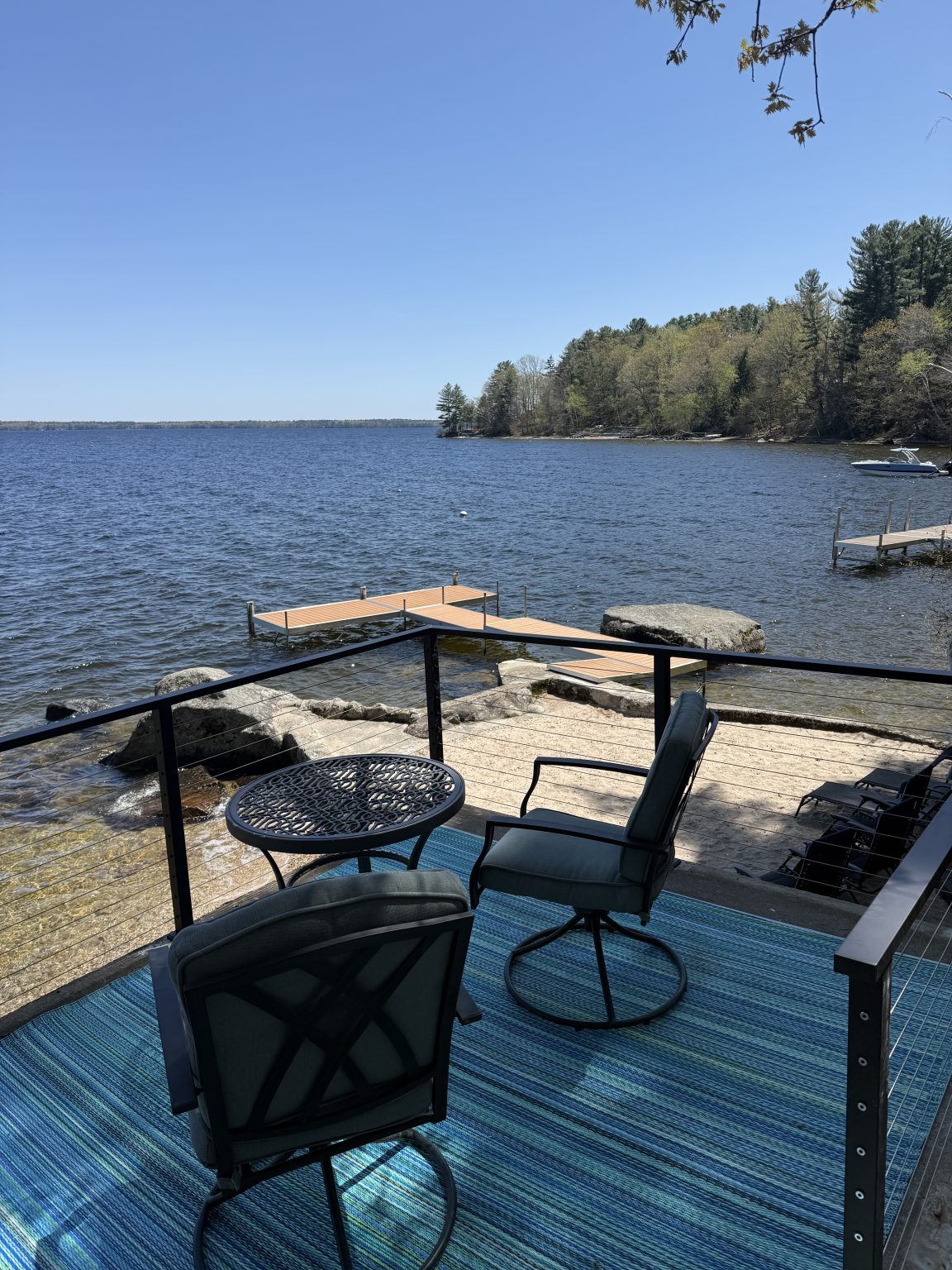 Outdoor table and chairs overlooking the water at Sebago Retreat
